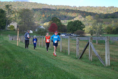 Four racers of all ages run the Sky Meadows 5K loop. 
