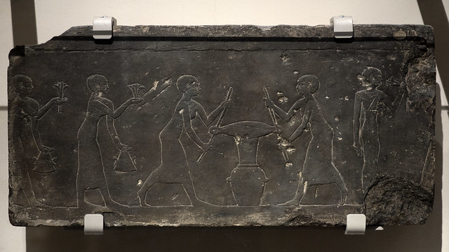 Egyptian limestone slab with relief representing women pressing lotus flowers