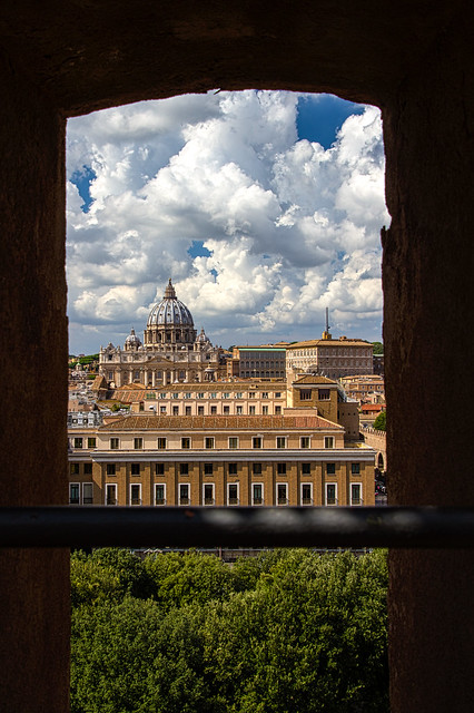 A battlement of Castel Sant’ Angelo frames the Basilica S. Petro (St Peter’s) in the Vatican City, Rome, Italy