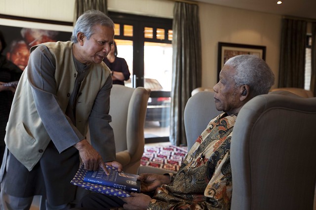 Yunus giving Mandela books on Grameen