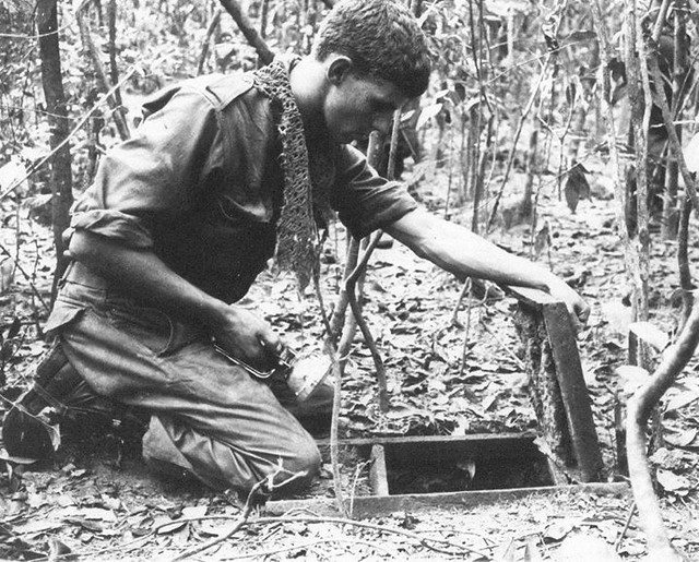 #An Australian sapper looks into a Viet Cong tunnel in the Ho Bo Woods, north-west of Saigon, during Operation Crimp. This operation marked the first time Allied (US and Australian) forces discovered and explored the VC's extensive tunnel network. Republi