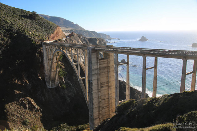 A bridge crossing a ravine with the sea in the background