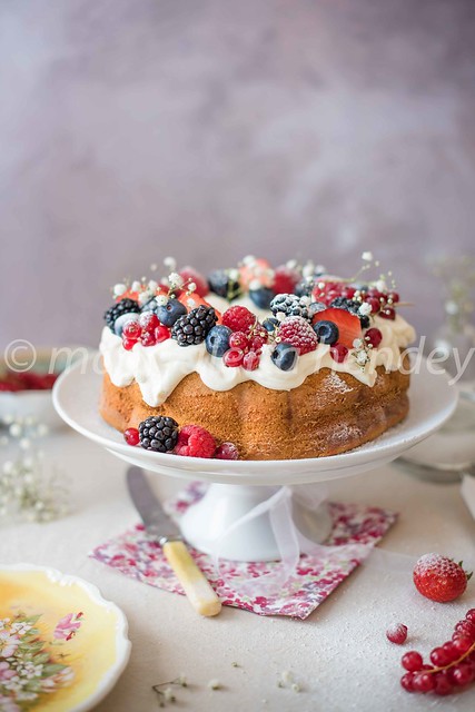 vanilla bundt cake with creme cheese icing and berries
