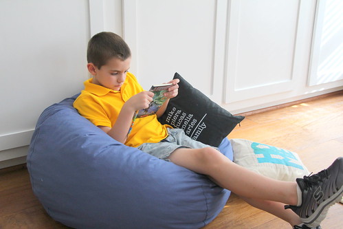 boy with book on bean bag chair | by PersonalCreations.com