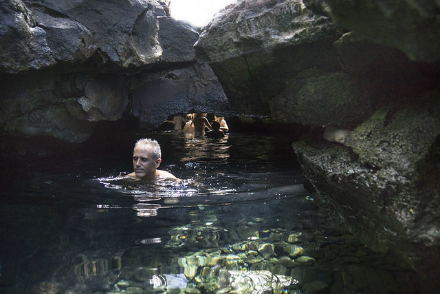 Bathing in a lava tube, Queen's Bath, on the Big Island, Hawaii, USA