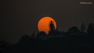 Sunset behind Buddha state of Wat Phra That Doi Kham, Buddhist temple in the historic of Chiang Mai, Thailand.