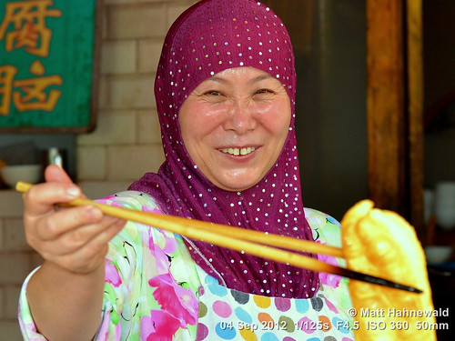 headscarf hijab travel smiling ethnic posing cultural street psychological primelens traditional respect authentic woman female religious matthahnewaldphotography facingtheworld china chinesecruller portrait huimuslim islam muslim muslimquarter nikond3100 shaanxi xian 50mm oilfriedbreadstick expression headshot lifestyle nikkorafs50mmf18g fullfaceview colour colourful clarity person consensual lookingatcamera muslimah
