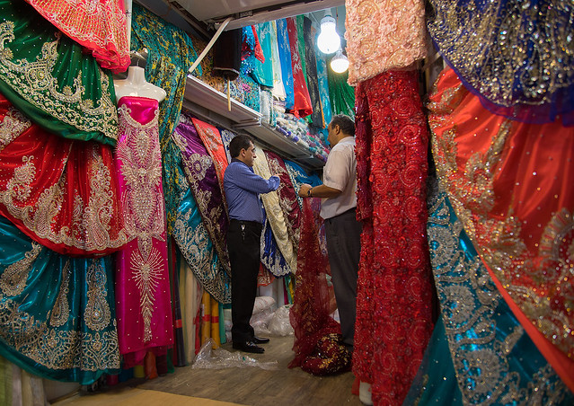 Man selling dresses in the clothes bazaar, Fars province, Shiraz, Iran