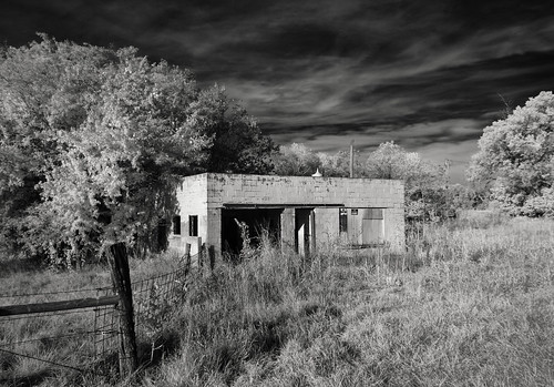 grass sky trees abandonedbusiness fence shadows abandonedgasstation clouds infrared signs utilitypoles opendoors monochrome neglect boardedupwindows blackandwhite fadedpaint