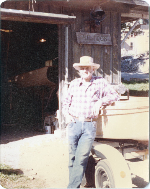 Bill Grunwald standing in front of his shop with a boat, circa 1960s-1980s[CR]circa 1960s-1980s[CR]circa 1960s-1980s