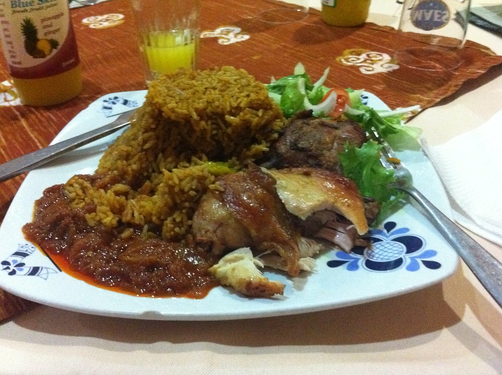 A plate of Jollof rice served with grilled chicken