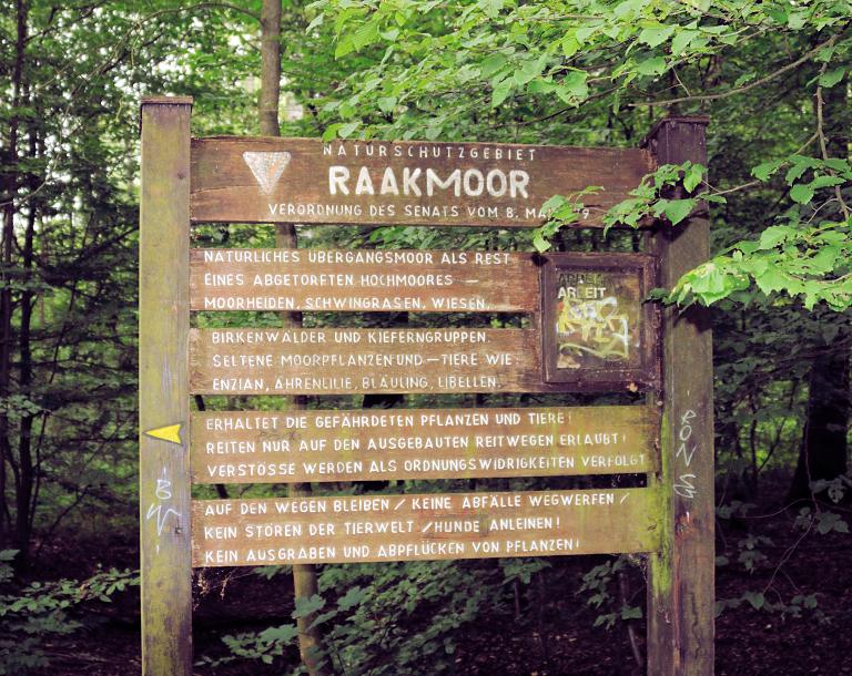 7856 Hinweisschild Naturschutzgebiet Raakmoor - natürliches Übergangsmoor als Rest eines abgetorften Hochmoors.