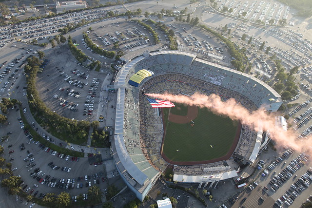 Sailor on Navy Parachute Team displays an American flag above Dodger Stadium during a baseball game
