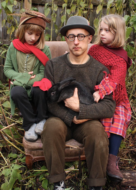 Father and daughters with rabbit in the garden