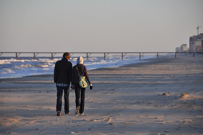 Couple meanders down a wintry beach along the Chesapeake Bay. 