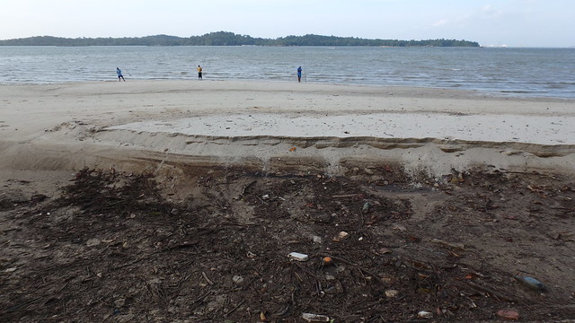 Large hole with oil on the high shore at Changi
