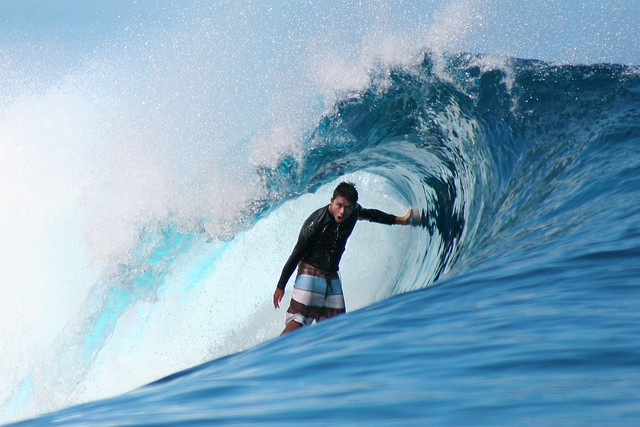 Pro-surfer Dennis Tihara surfing the waves at Teahupoo, Tahiti.