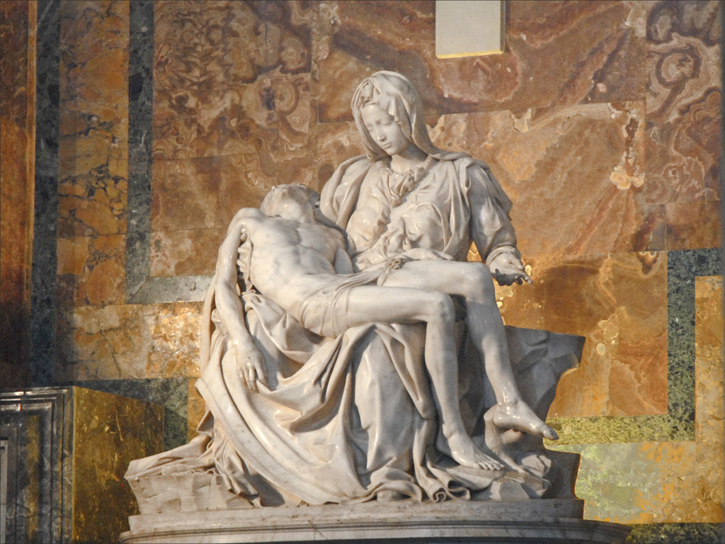 A photo of the La Pietà de Michel-Ange statue in the Vatican. The Virgin Mary is depicted sorrowful and holding her son after his crucifixion.  