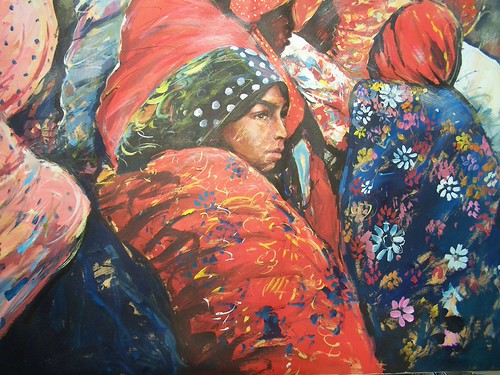 Woman in a green head wrap and patterned shawl