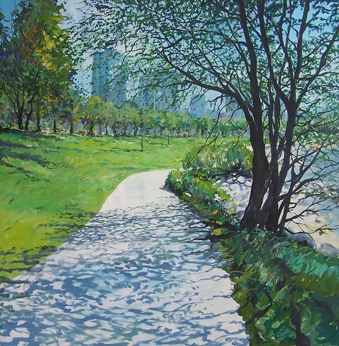 Paved waterside path beneath leafy trees