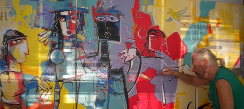 Artist working beside a colourful group composition
