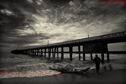 A Fisherman with Some Fresh Catch [ BW Version ] by Sukanta Maikap Photography, Pondicherry has this old jetty at the south end of Pondicherry beach alongside a platform made of bo