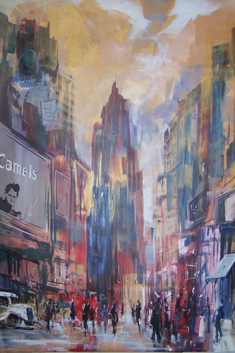 Tall street buildings beneath a pale cloudy sky