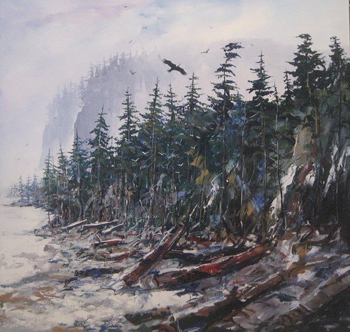 Driftwood along a foggy evergreen shoreline