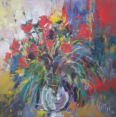 Red flowers and green leaves in a pale vase