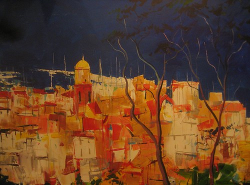 Golden coastal town beneath a dark blue sky