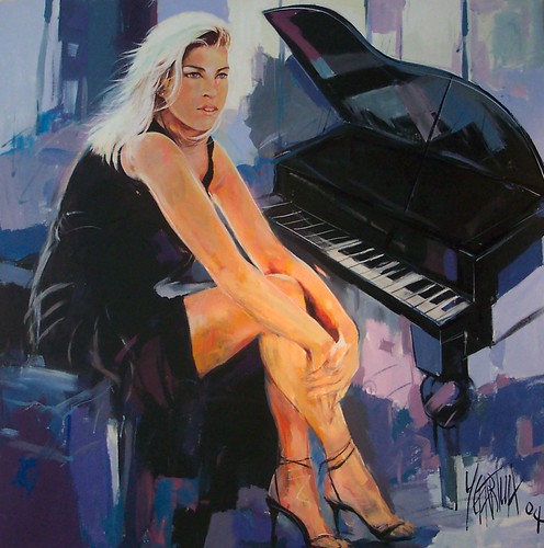Seated woman beside a black grand piano
