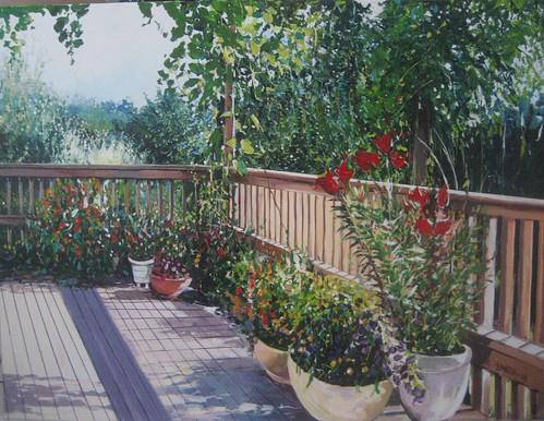 Potted flowers along a wooden balcony railing