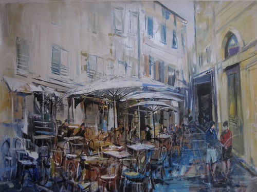 Outdoor restaurant seating beneath pale buildings