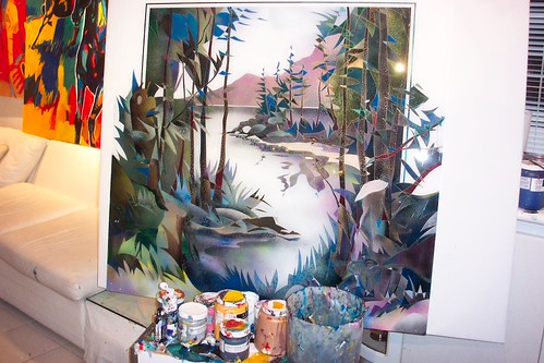Framed forest river painting displayed in a studio