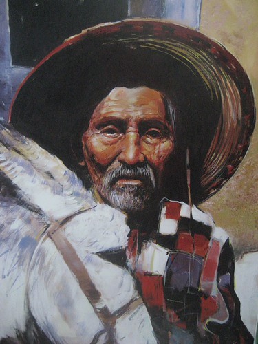 Man in a broad hat beside a donkey