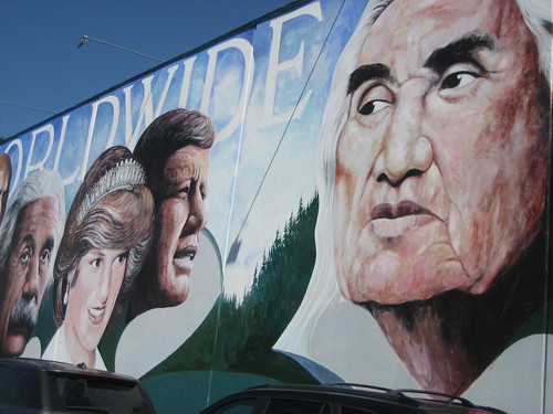 Large portrait faces across a blue exterior wall