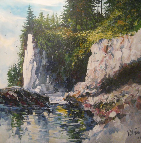 Steep rocky shoreline beneath evergreen trees