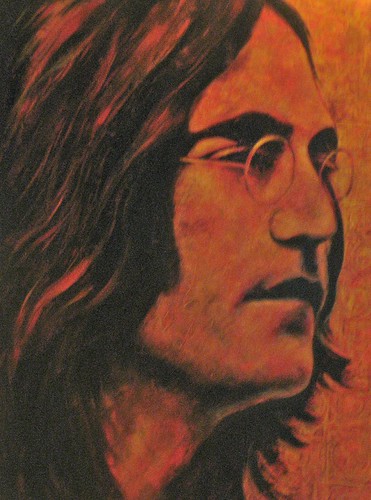 Long-haired musician in profile against orange