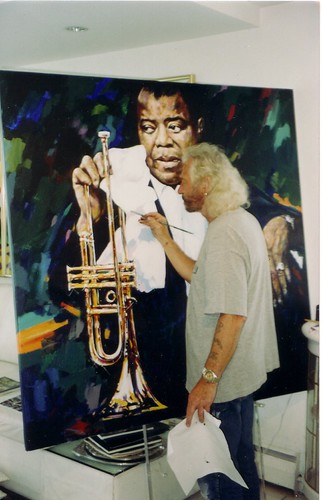 Artist standing beside his painting of a trumpeter