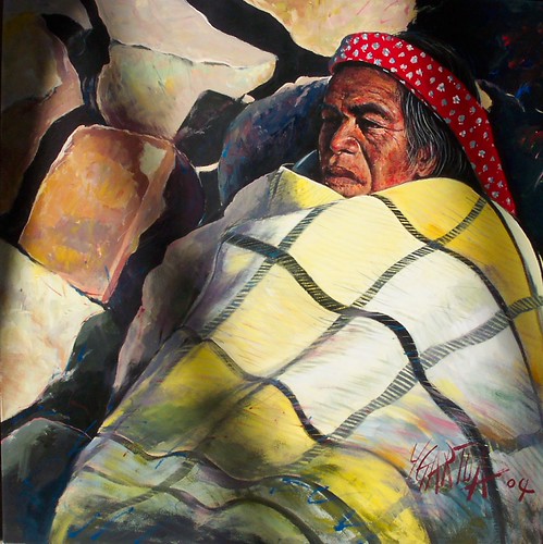 Seated man wrapped in a patterned blanket