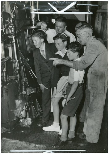 Chief officer George Todd, right, and his asistant Bob Luther explain the engine to John Rae, Jim Swan and James Wilton, on the ocean cruise to Broken Bay, South Steyne, December 1953 / Australian Women's Weekly photograph | by State Library of NSW