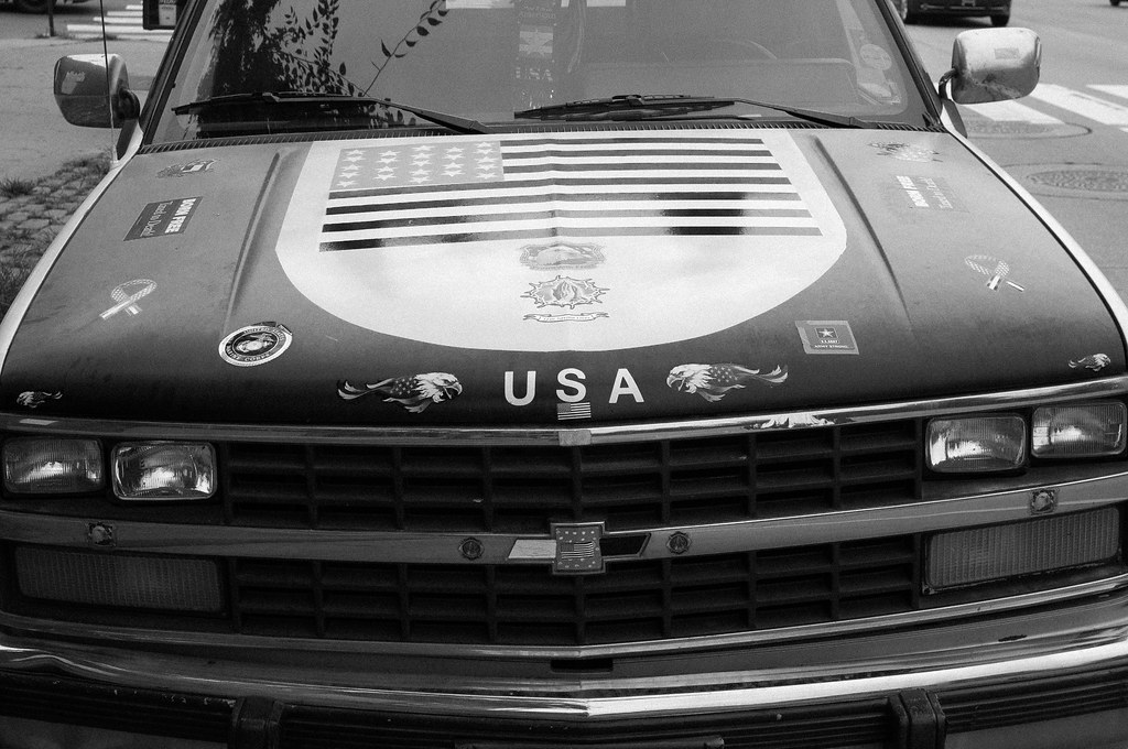 Vintage Chevrolet pickup truck hood adorned with an American flag decal, eagle graphics, and USA lettering.