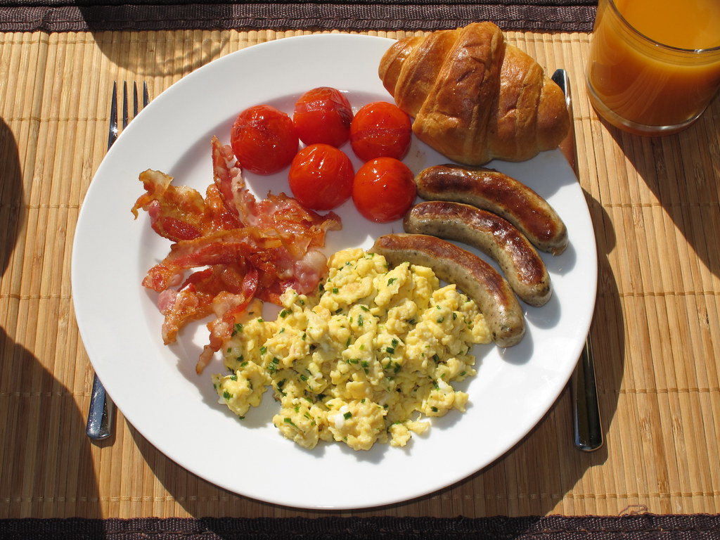 Frühstück mit Rührei, Speck, Tomaten, Würstchen und Croiss… | Flickr