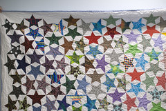 On my last week at the library, I asked Lexie if she could bring in her quilt so I could finally have a full photo of it. This is Star Stories, three years later, after use and love.

For the archive page about the quilt, see domesticat.net/quilts/star-stories

For an excellent full write-up of what this quilt was, and why the fabrics had meaning, see domesticat.net/2009/10/quilt-festival-story-star-stories