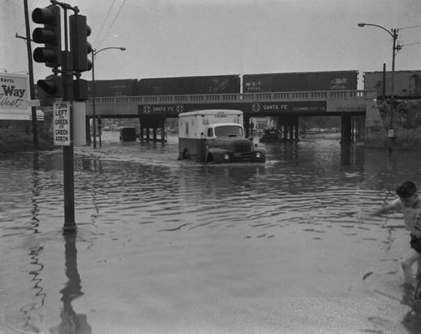 The flooded intersection of South Archer Avenue and West 47th Street in Chicago's Brighton Park neighborhood.  Chicago Illinois USA. Circa 1960's.