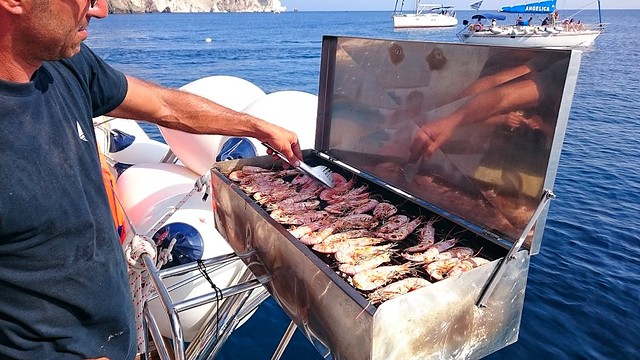 Santorini sailing - crew grilling shrimp on the ship deck