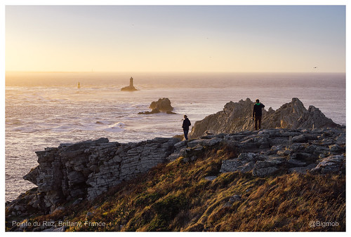 sunset sea atlantic coast water dusk woman man dog rock cap