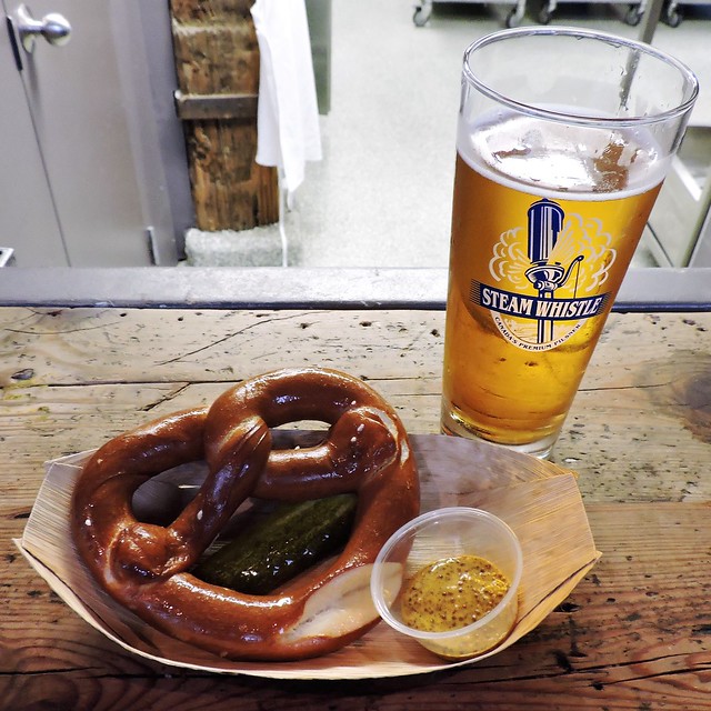 Steam Whistle Pilsner; pretzel with Steam Whistle mustard, and a pickle