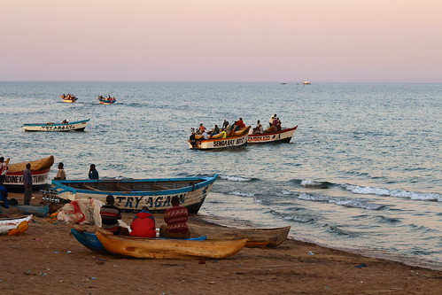 malawi africa men fishermen boats sunset light natural wood sand lake water working watching people locals travel photography african workers sailing blue pink waiting senga bay shore hard photographer backpacking outdoor lifestyle rural life beach waterscape fishing