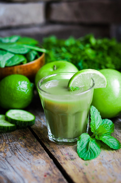 Green smoothie with apples,parsley,spinach,cucumber,lime and mint on rustic wood
